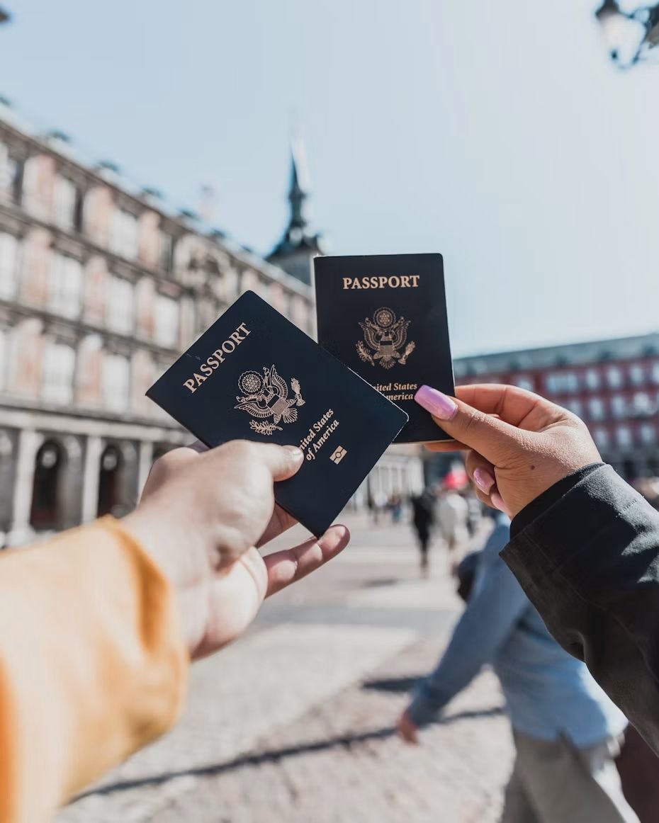 Dos personas muestran sus pasaportes en la Plaza Mayor de Madrid